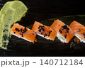 Salmon roll. Seafood dish. Row sushi with black caviar red ikura wasabi sauce on black. Oriental menu meal with herb sprouts. 140712184