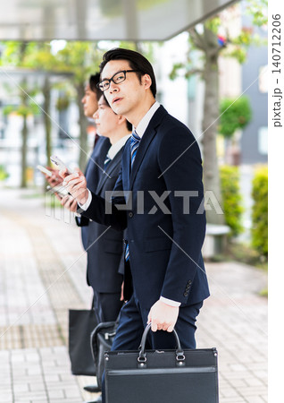 バス停でバスを待つスーツ姿の男性 バス停でバスを待つスーツ姿の男性 140712206