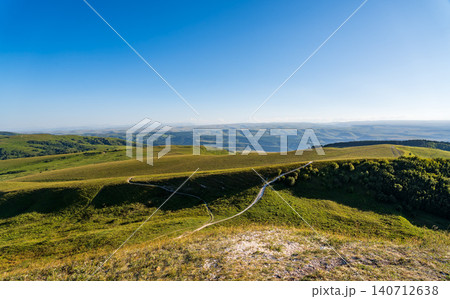 Layers of green mountains and hills in the haze during sunset. Panoramic View of Green hills and Meadow. Layers of green mountains and hills in the haze during sunset. Panoramic View of Green hills and Meadow. 140712638