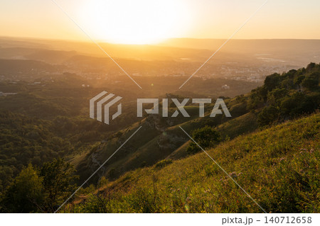View of the mountains and Kislovodsk from the observation decks of the Kislovodsk Park. Evening sunset over the mountains of Kislovodsk. View of the mountains and Kislovodsk from the observation decks of the Kislovodsk Park. Evening sunset over the mountains of Kislovodsk. 140712658