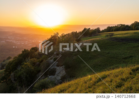 View of the mountains and Kislovodsk from the observation decks of the Kislovodsk Park. Evening sunset over the mountains of Kislovodsk. 140712668