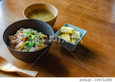 スプーンと牛丼、味噌汁、パイナップルのセット料理 140712880