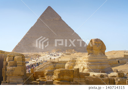 Giza, Egypt - 11 03 2023, a panoramic view of Great Pyramids of Giza and Sphinx on foreground. At daytime, with many of tourist on background, Giza, Egypt Giza, Egypt - 11 03 2023, a panoramic view of Great Pyramids of Giza and Sphinx on foreground. At daytime, with many of tourist on background, Giza, Egypt 140714315