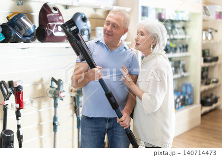 Married couple chooses vacuum cleaner together at supermarket 140714473