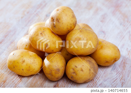 Raw potato tubers on a wooden table Raw potato tubers on a wooden table 140714655