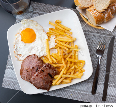 Plate with prepared food pork chop with french fries and fried egg closeup 140714699