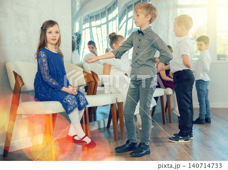 Preteen boy inviting girl to dance during children festive event 140714733
