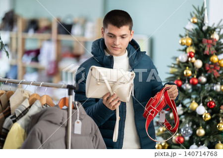 Guy choosing a handbag for a gift in the store Guy choosing a handbag for a gift in the store 140714768