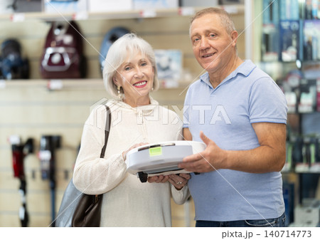 Married couple chooses robot vacuum cleaner together at supermarket Married couple chooses robot vacuum cleaner together at supermarket 140714773