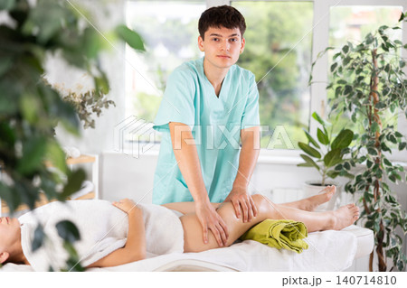 Male masseur doing massage at back young woman who lying on massage table in beauty salon Male masseur doing massage at back young woman who lying on massage table in beauty salon 140714810
