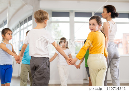 Children holding hands and dancing in round dance in choreography class Children holding hands and dancing in round dance in choreography class 140714841