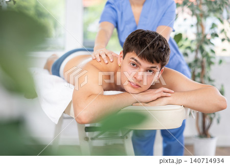 Female massagist doing massage to male client in spa center Female massagist doing massage to male client in spa center 140714934