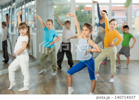 Girl learn to dance modern dances, doing movement with unrecognizable teacher. Girl learn to dance modern dances, doing movement with unrecognizable teacher. 140714937