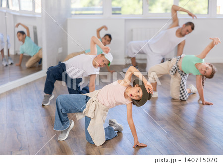 Preteen boys and girls studying movement of contemporary dance in classroom with his friends 140715020