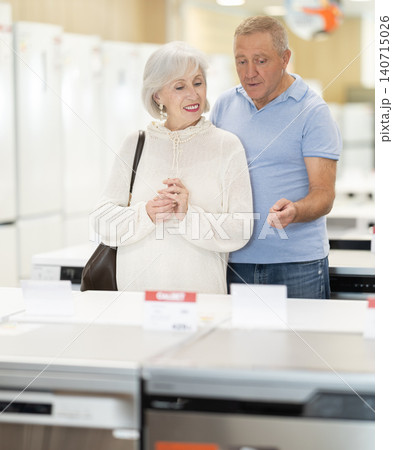 Elderly couple choosing a washing machine in a store Elderly couple choosing a washing machine in a store 140715026