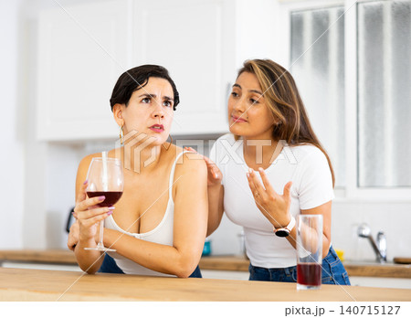 Sadness woman has problem, girlfriend consoling her at table in kitchen Sadness woman has problem, girlfriend consoling her at table in kitchen 140715127