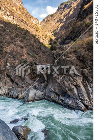 Landscape of an old bridge opposite the landscape of Tiger Leaping Gorge in Yunnan province of China. Landscape of an old bridge opposite the landscape of Tiger Leaping Gorge in Yunnan province of China. 140715531
