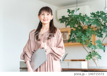 ノートパソコンを持つおしゃれな中高年の女性（オフィスカジュアル・デザイナー・ビジネスウーマン） 140715572