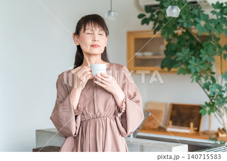 キッチン・ダイニングでコーヒー・紅茶を飲む中高年のアジア人女性 キッチン・ダイニングでコーヒー・紅茶を飲む中高年のアジア人女性 140715583