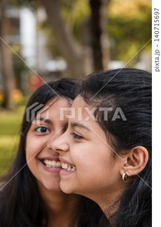 Portrait of Two Happy Sisters Smiling Together in Park Portrait of Two Happy Sisters Smiling Together in Park 140715697