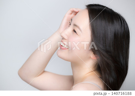 笑顔で風になびく美しい女性 素肌と艶やかな髪が印象的な美容ビューティーポートレート 笑顔の横顔 笑顔で風になびく美しい女性 素肌と艶やかな髪が印象的な美容ビューティーポートレート 笑顔の横顔 140716188