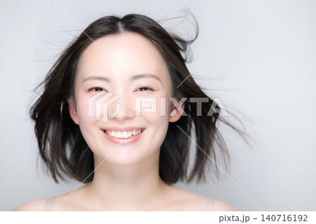 笑顔で風になびく美しい女性 素肌と艶やかな髪が印象的な美容ビューティーポートレート カメラ目線の笑顔 笑顔で風になびく美しい女性 素肌と艶やかな髪が印象的な美容ビューティーポートレート カメラ目線の笑顔 140716192