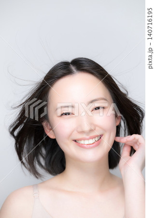 笑顔で風になびく美しい女性 素肌と艶やかな髪が印象的な美容ビューティーポートレート カメラ目線の笑顔 笑顔で風になびく美しい女性 素肌と艶やかな髪が印象的な美容ビューティーポートレート カメラ目線の笑顔 140716195