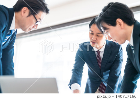 会議室で真剣に意見を交わすスーツ姿のビジネスマン3人 会議室で真剣に意見を交わすスーツ姿のビジネスマン3人 140717166