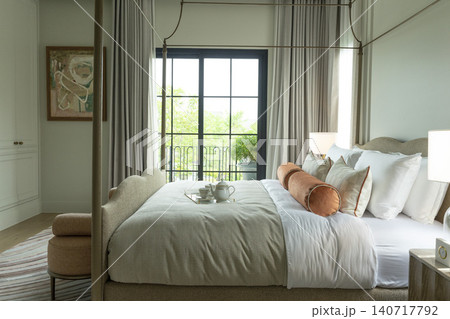 King Size Canopy Bed Frame with pillows in elegant bedroom interior. Honeymoon suite bedroom in pastel and pink colors style bedroom in white room Boudoir. King Size Canopy Bed Frame with pillows in elegant bedroom interior. Honeymoon suite bedroom in pastel and pink colors style bedroom in white room Boudoir. 140717792