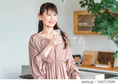 キッチンで水分補給をする中高年のアジア人女性 キッチンで水分補給をする中高年のアジア人女性 140717999
