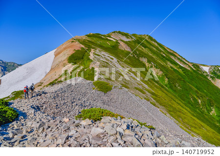 夏の晴天 小蓮華山山頂付近のガレ場の登山道を歩く登山客の後ろ姿と残雪風景 夏の晴天 小蓮華山山頂付近のガレ場の登山道を歩く登山客の後ろ姿と残雪風景 140719952