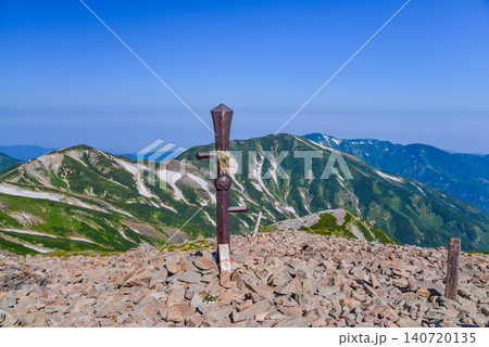 夏の快晴 小蓮華山山頂に立つ鉄剣と背景に望む鉢ヶ岳・雪倉岳の残雪美しい山肌風景 夏の快晴 小蓮華山山頂に立つ鉄剣と背景に望む鉢ヶ岳・雪倉岳の残雪美しい山肌風景 140720135