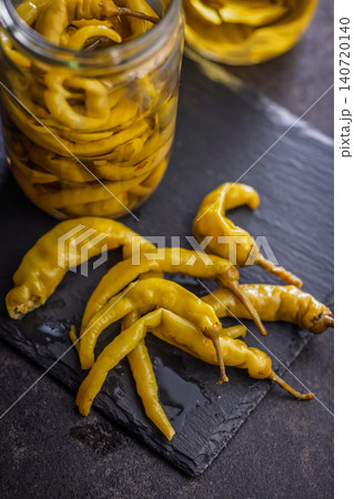 Pickled Yellow Chili Peppers On Slate With Glass Jars Of Brine. Close-Up Food Still Life Pickled Yellow Chili Peppers On Slate With Glass Jars Of Brine. Close-Up Food Still Life 140720140