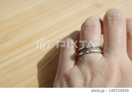 結婚・婚約指輪を重ね付けした女性の手元 結婚・婚約指輪を重ね付けした女性の手元 140720859