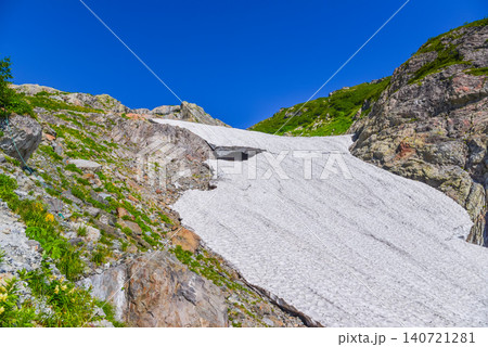 夏の快晴 白馬大雪渓の岩肌の間を流れるように広がる雄大な雪渓上部の風景 140721281