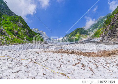 夏の快晴 白馬大雪渓の最下部から望む雪の壁と青空にそびえる白馬岳の頂き風景 夏の快晴 白馬大雪渓の最下部から望む雪の壁と青空にそびえる白馬岳の頂き風景 140721434