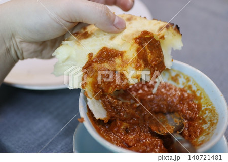 Hand Holding Cheesy Pasta Dish with Tomato Sauce 140721481