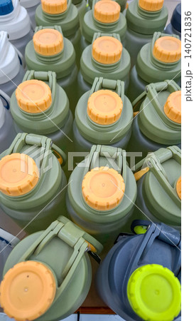 Group of green plastic sports water bottles with orange caps 140721836