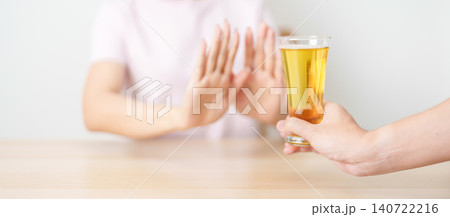 woman making stop hand gesture to refuse a glass of Beer, Healthy man say no to alcohol drink, stop alcoholism and addiction concept. Responsible man reject a drink before driving and quit booze 140722216