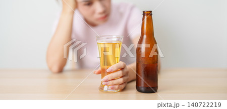 Stressed woman drinking beer alone with problem. Exhausted drunk woman looking stressed and sleepy. Alcohol addiction, Alcoholism, emotional distress and mental health concept Stressed woman drinking beer alone with problem. Exhausted drunk woman looking stressed and sleepy. Alcohol addiction, Alcoholism, emotional distress and mental health concept 140722219