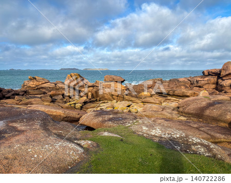 Pink granite boulders scattered along sandy shore in Tregastel, France Pink granite boulders scattered along sandy shore in Tregastel, France 140722286