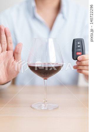 Responsible man reject a drink before driving for road safety, man making stop hand gesture to refuse a glass of Wine and car remote. Avoid drink and drive, Drunk Driving Law concept Responsible man reject a drink before driving for road safety, man making stop hand gesture to refuse a glass of Wine and car remote. Avoid drink and drive, Drunk Driving Law concept 140722296