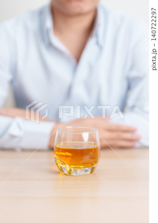 man with glass of whiskey on table, suffering from alcohol addiction and alcoholism concept. depicting emotional distress, depression, substance abuse problem, unhealthy lifestyle and mental health man with glass of whiskey on table, suffering from alcohol addiction and alcoholism concept. depicting emotional distress, depression, substance abuse problem, unhealthy lifestyle and mental health 140722297