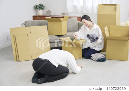 引越し中に謝る男性と怒る女性の夫婦喧嘩 引越し中に謝る男性と怒る女性の夫婦喧嘩 140722989