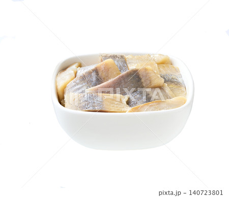 pieces of herring fillet on a white bowl isolated on a white background. pieces of herring fillet on a white bowl isolated on a white background. 140723801