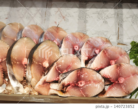 Close up of fresh raw sliced mackerel tuna (ikan tongkol) displayed on ice at a traditional seafood market. Close up of fresh raw sliced mackerel tuna (ikan tongkol) displayed on ice at a traditional seafood market. 140723852