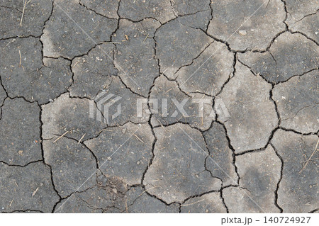 Dried cracked earth revealing soil and cracks under bright sunlight in a dry area during summer season Dried cracked earth revealing soil and cracks under bright sunlight in a dry area during summer season 140724927