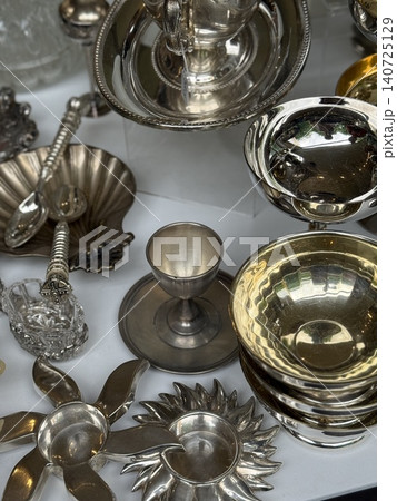 Silverware assortment displayed with various bowls, cups, and utensils as a background 140725129