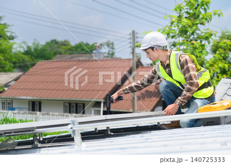 Solar Panel Installer Technician Working on Rooftop with Power Drill and Safety Equipment Solar Panel Installer Technician Working on Rooftop with Power Drill and Safety Equipment 140725333