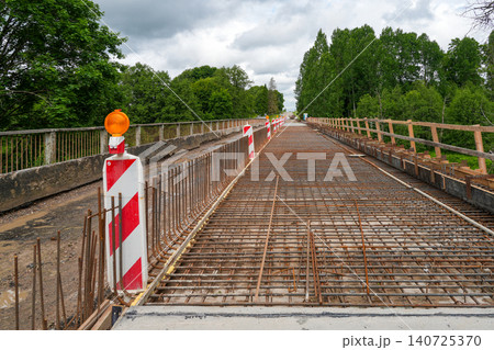 Bridge repair with exposed rebar over the Barta River in Latvia, construction barriers in place 140725370